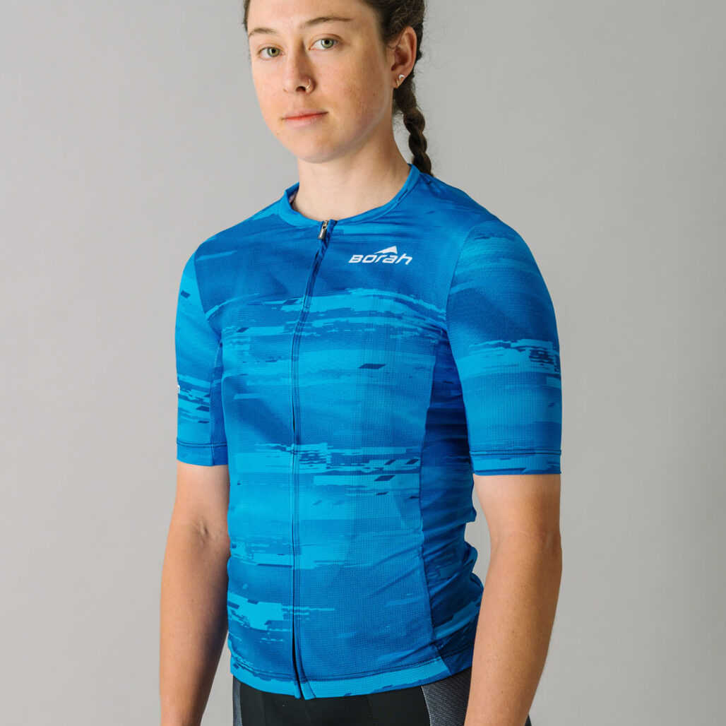 Front view of a female model wearing a blue custom Women's OTW Cycling Jersey.