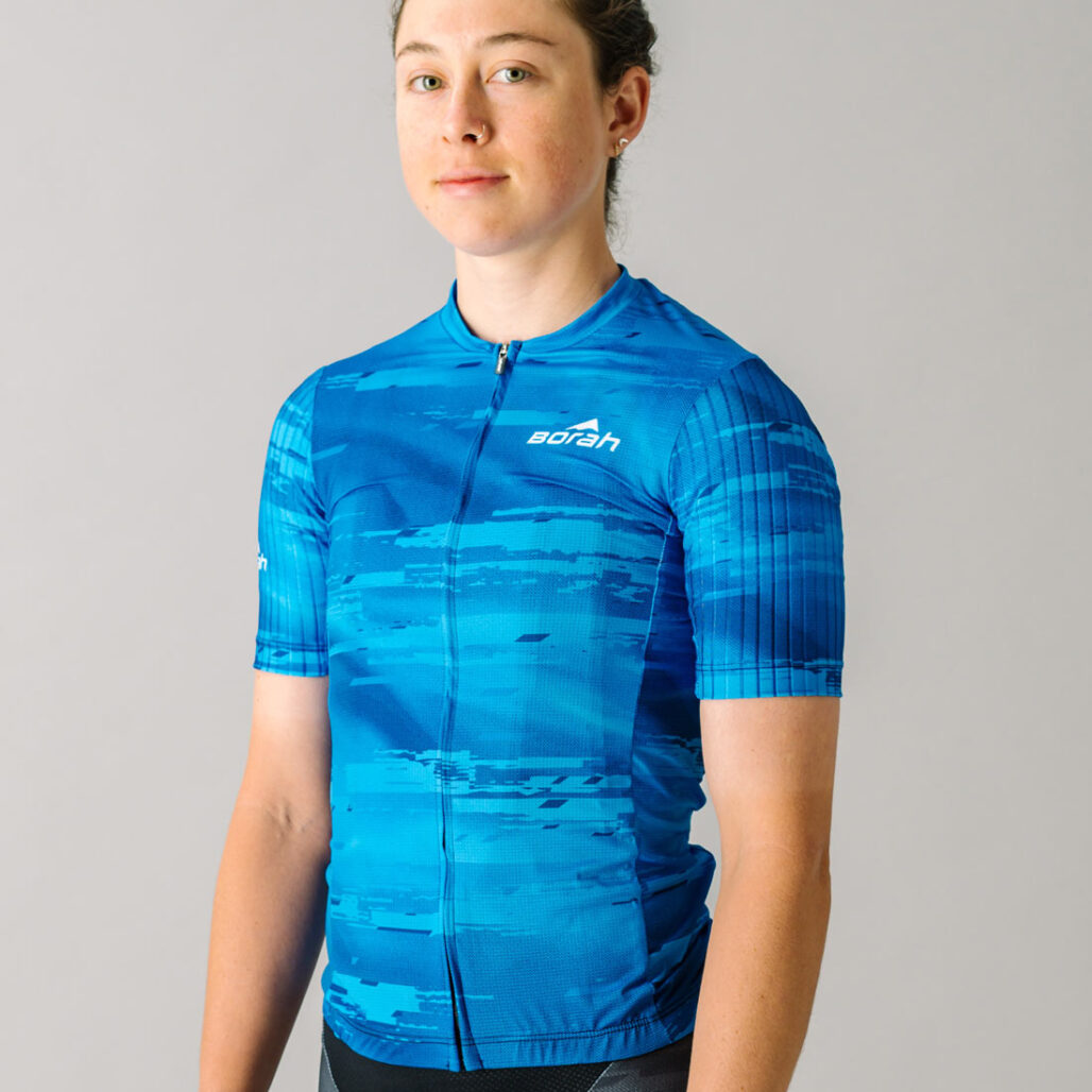 Front view of a female model wearing a blue custom Women's OTW Spark Cycling Jersey.