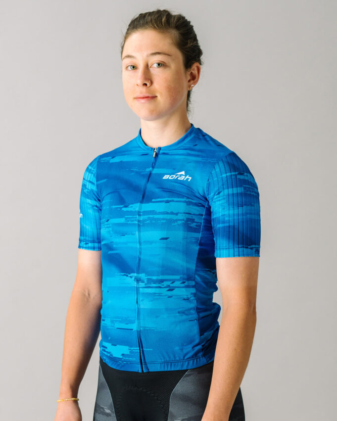 Front view of a female model wearing a blue custom Women's OTW Spark Cycling Jersey.