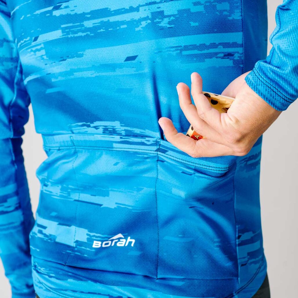 Reaching for a snack in the back pocket of the Team Long Sleeve Cycling Jersey.