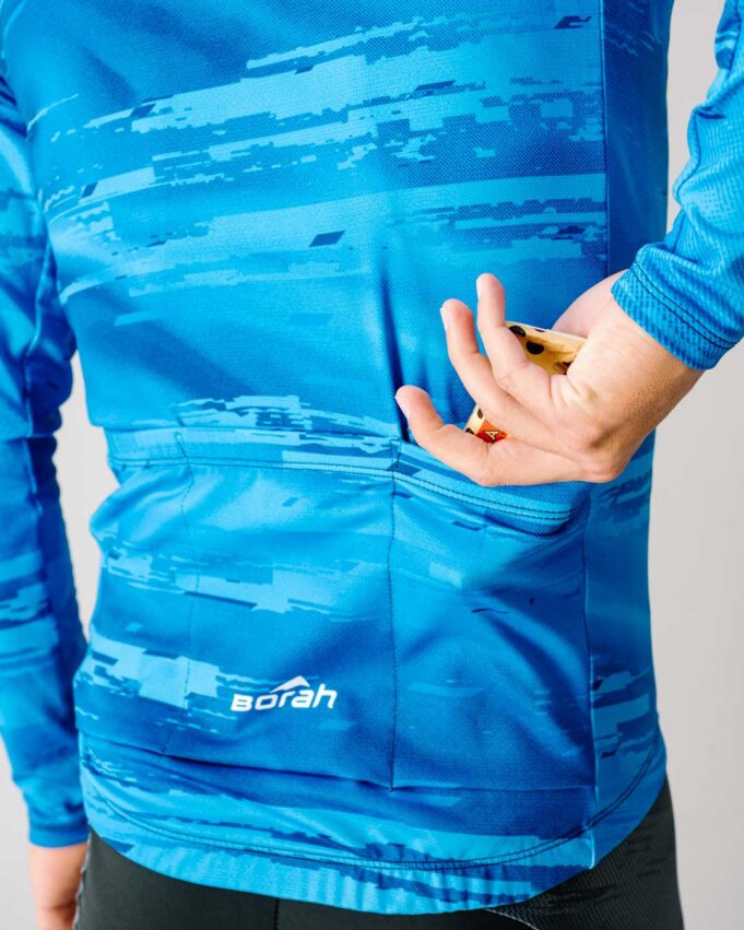 Reaching for a snack in the back pocket of the Team Long Sleeve Cycling Jersey.