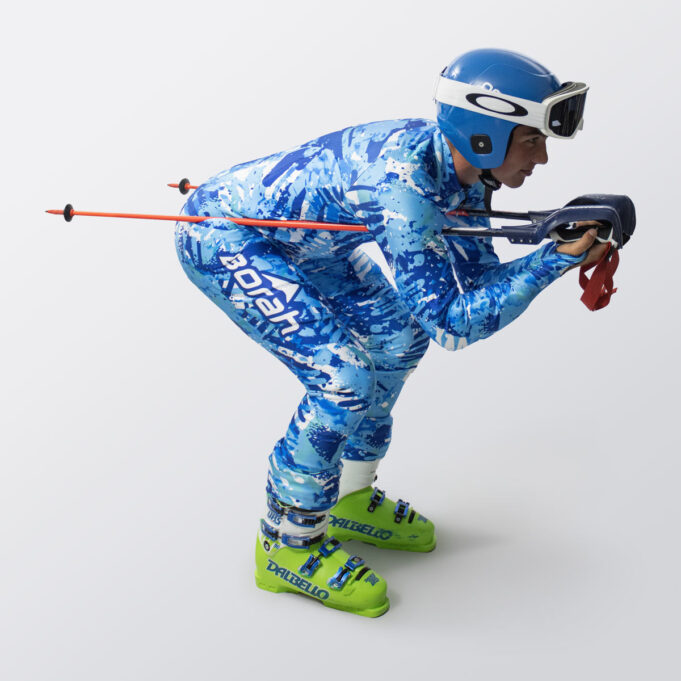 A young male athlete in full race tuck, wearing his custom alpine race suit by Borah.