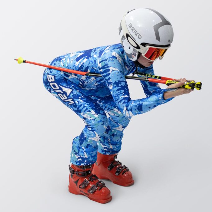 A young athlete in full race tuck, wearing their custom Youth Alpine Race Suit by Borah.