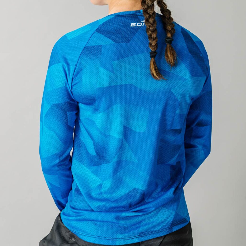 Back facing photo of a female wearing the new Women's Pro Long Sleeve Freeride MTB Jersey.
