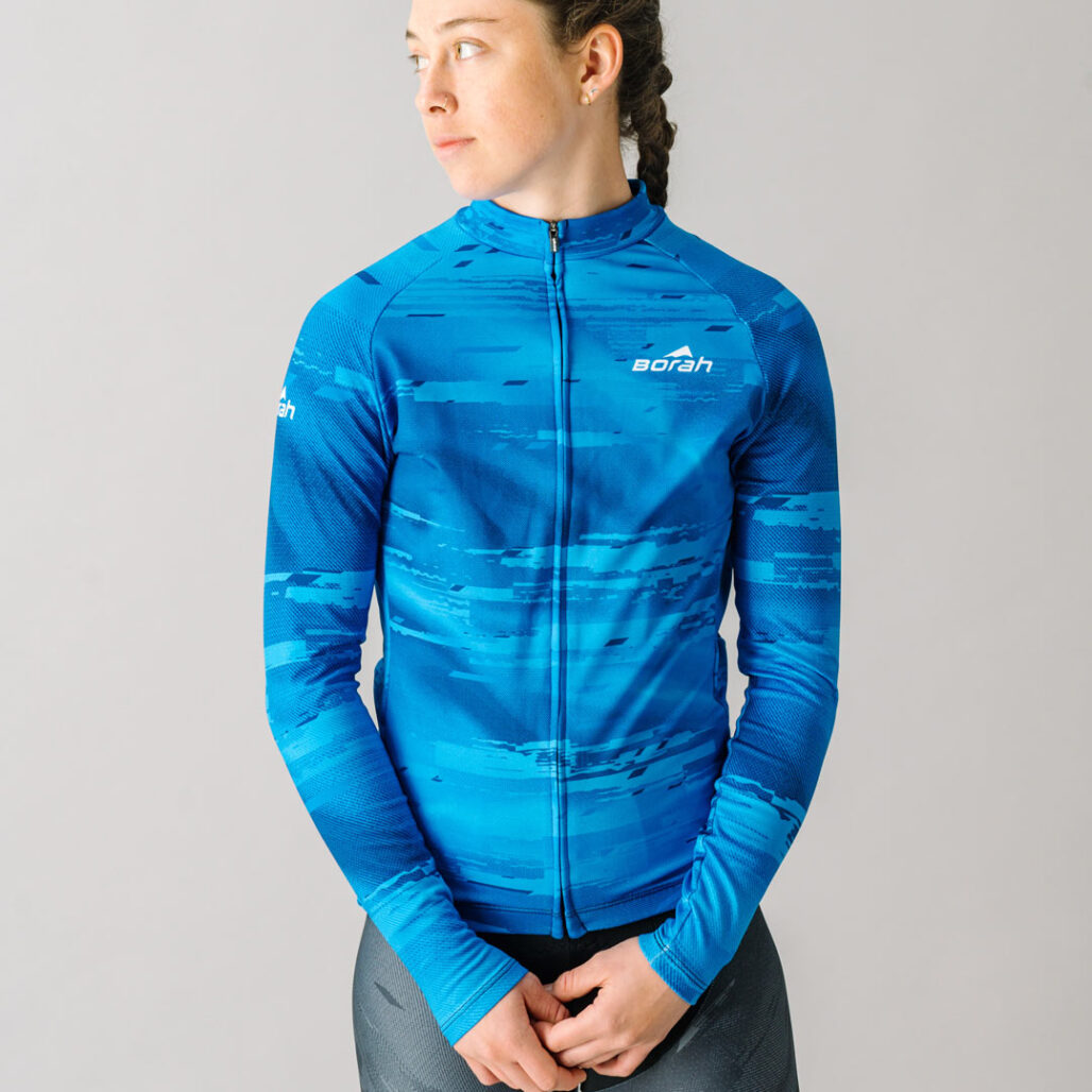 Front view of a female model wearing a blue custom Women's Team Long Sleeve Cycling Jersey.