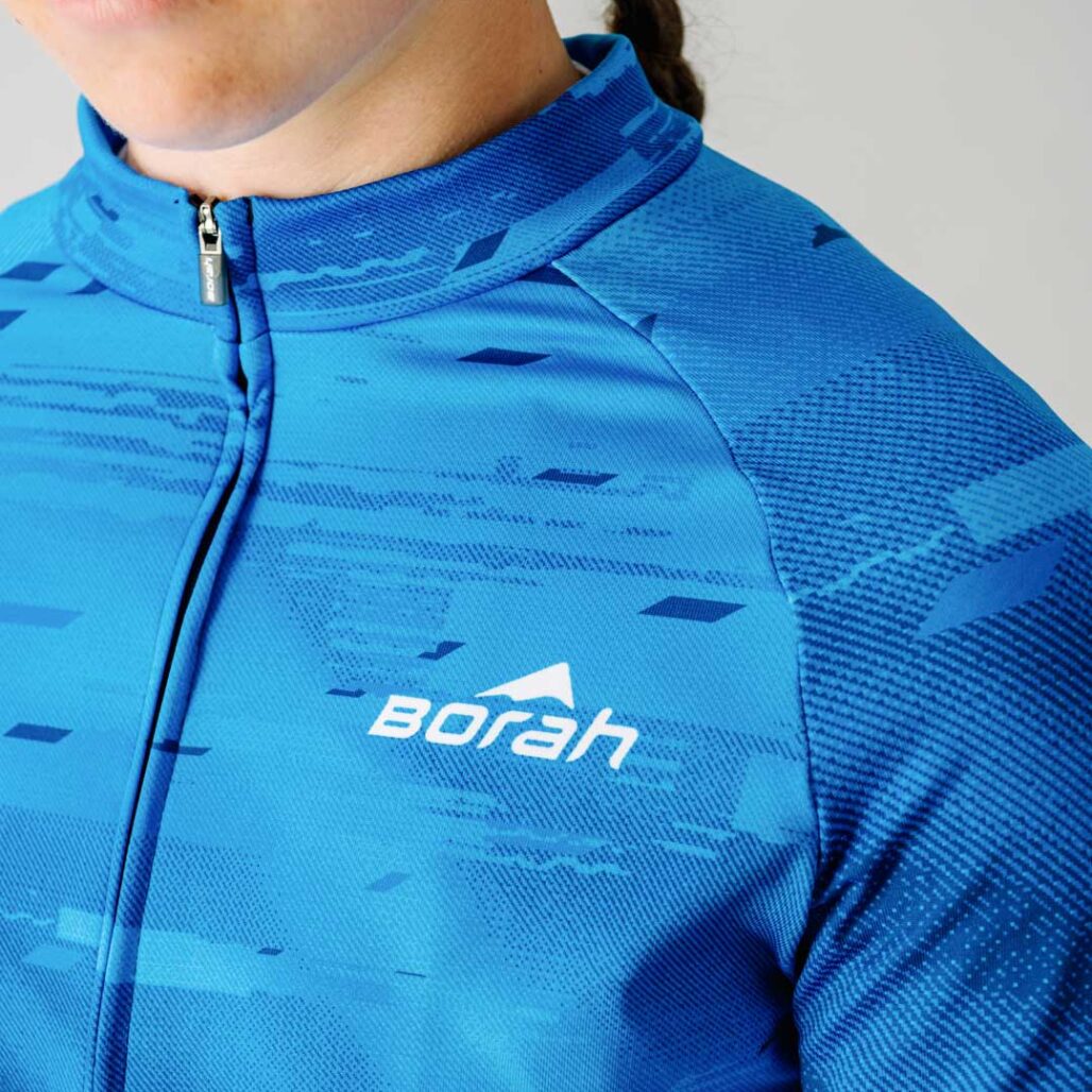 Close up of a female model wearing a blue custom Women's Team Long Sleeve Cycling Jersey.