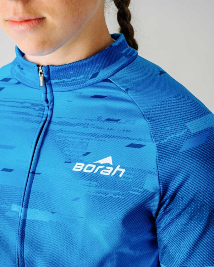 Close up of a female model wearing a blue custom Women's Team Long Sleeve Cycling Jersey.