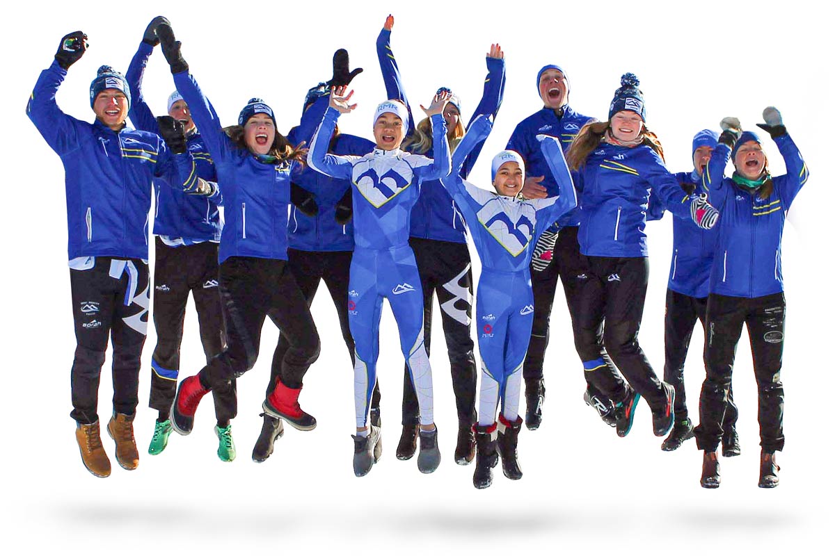 ski team athletes with raised hands jumping into the air for a fun photo.