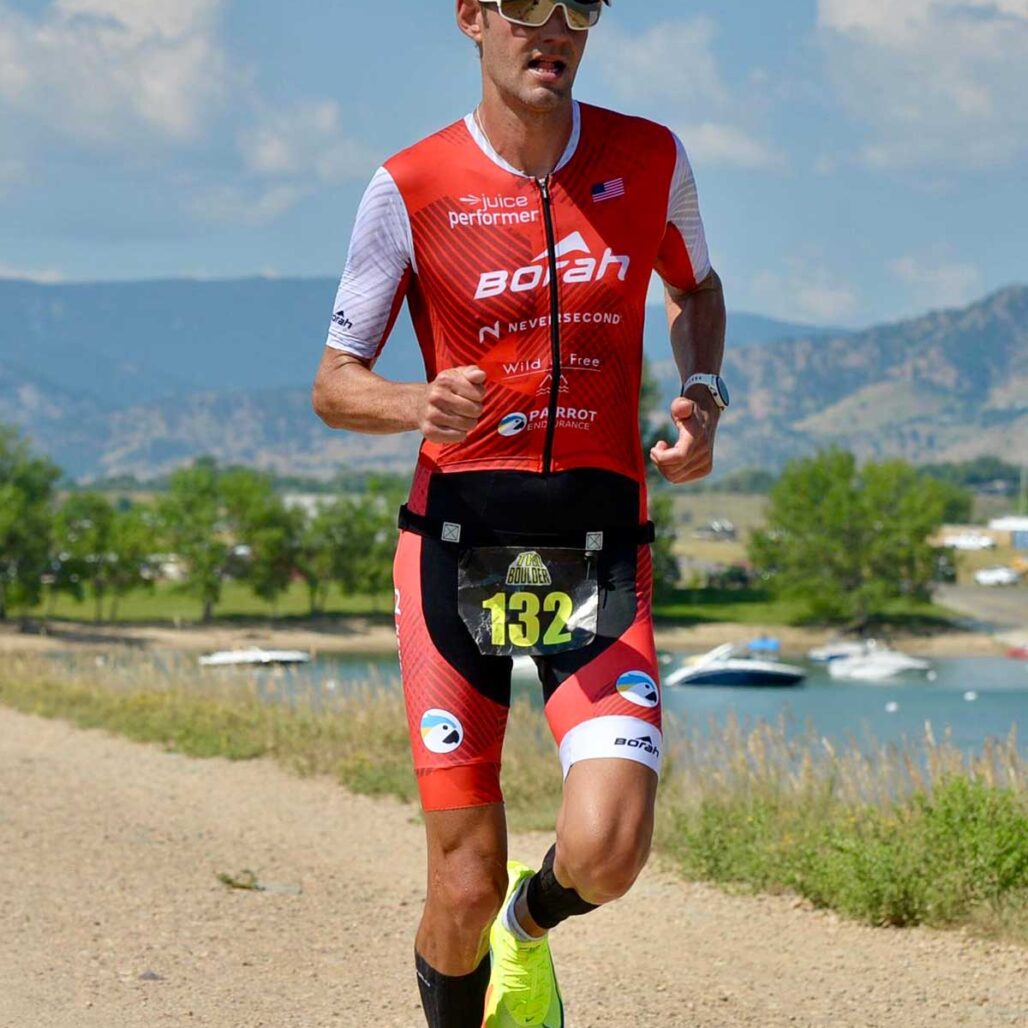 Athlete running down a gravel path wearing a custom OTW Turbo Tri Skinsuit.