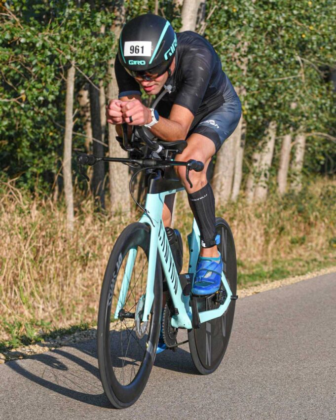 Triathlete riding a bicycle in Ironman race wearing a prototype OTW Turbo Tri Skinsuit by Borah.